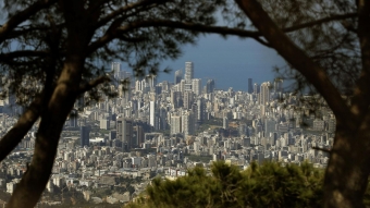 The cityscape of Beirut, Lebanon is visible behind trees in the foreground.