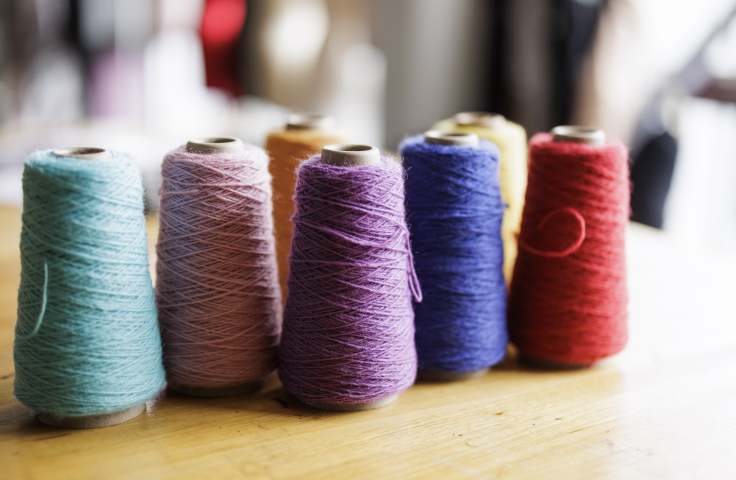 Thread spools in different colours: light blue, light pink, peach, violet, dark blue, cream and red