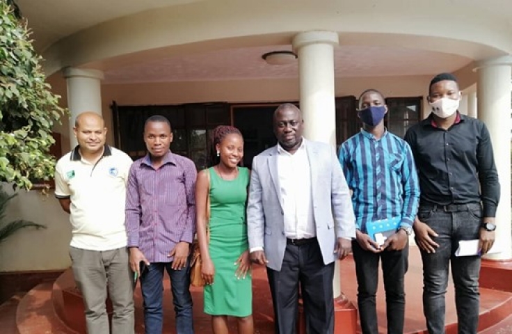Co-founders of ASEI and collaborators are standing in a line facing the camera. There are 5 men and 1 woman. Two men on the far right are wearing masks. The group is standing in front of a small outdoor foyer with columns.