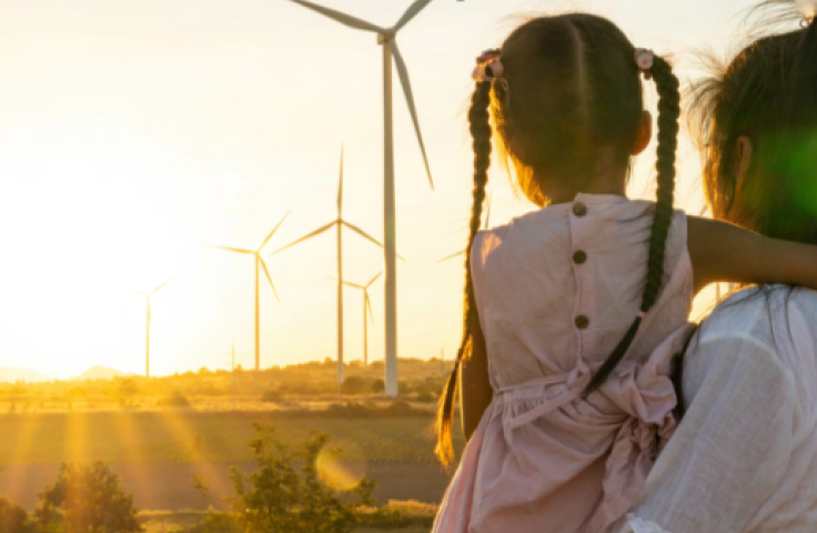 IGD Accelerating the Asia Pacific towards the SDGs front cover with image of woman holding child in her arms looking at wind turbines in the distance