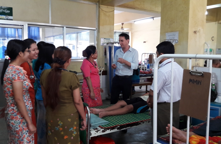 Clinicians in Myanmar in discussion in a ward.