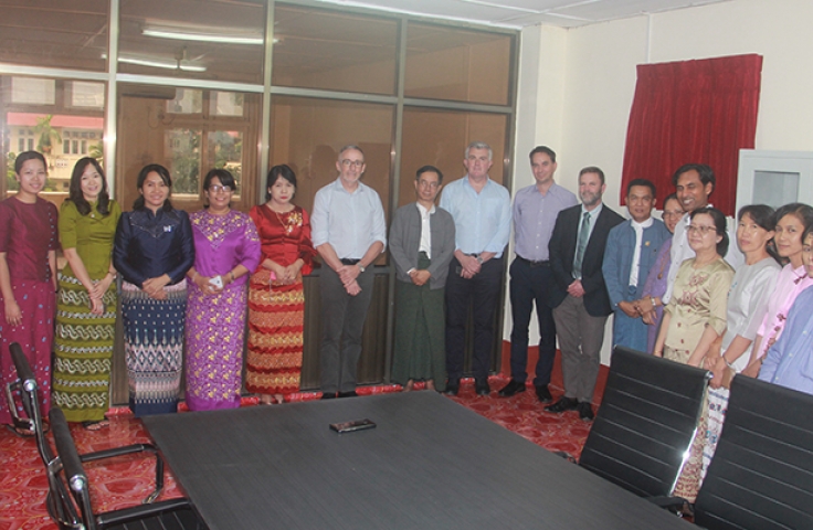 Burmese and UNSW colleagues stand around a room