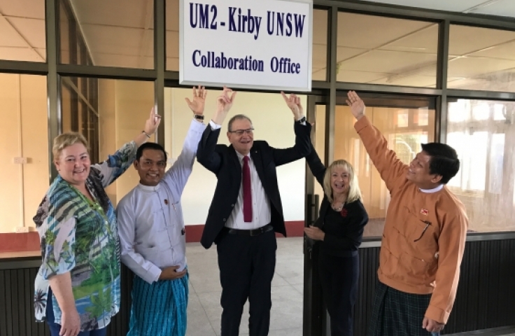 5 people point to a sign that reads "UM2 - Kirby UNSW Collaboration Office"