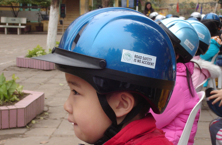 A group of young girls are wearing helmets that say 'Road safety is no accident'