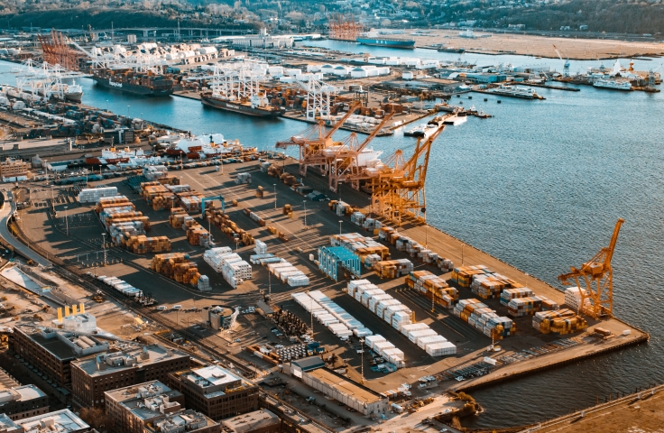 This image shows a port with various cranes and shipping containers from an aerial view.